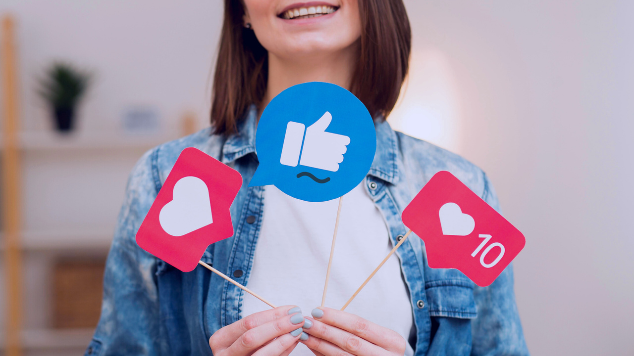 Mulher segurando bandeiras de mídias sociais. Imagem simboliza o Social Selling.