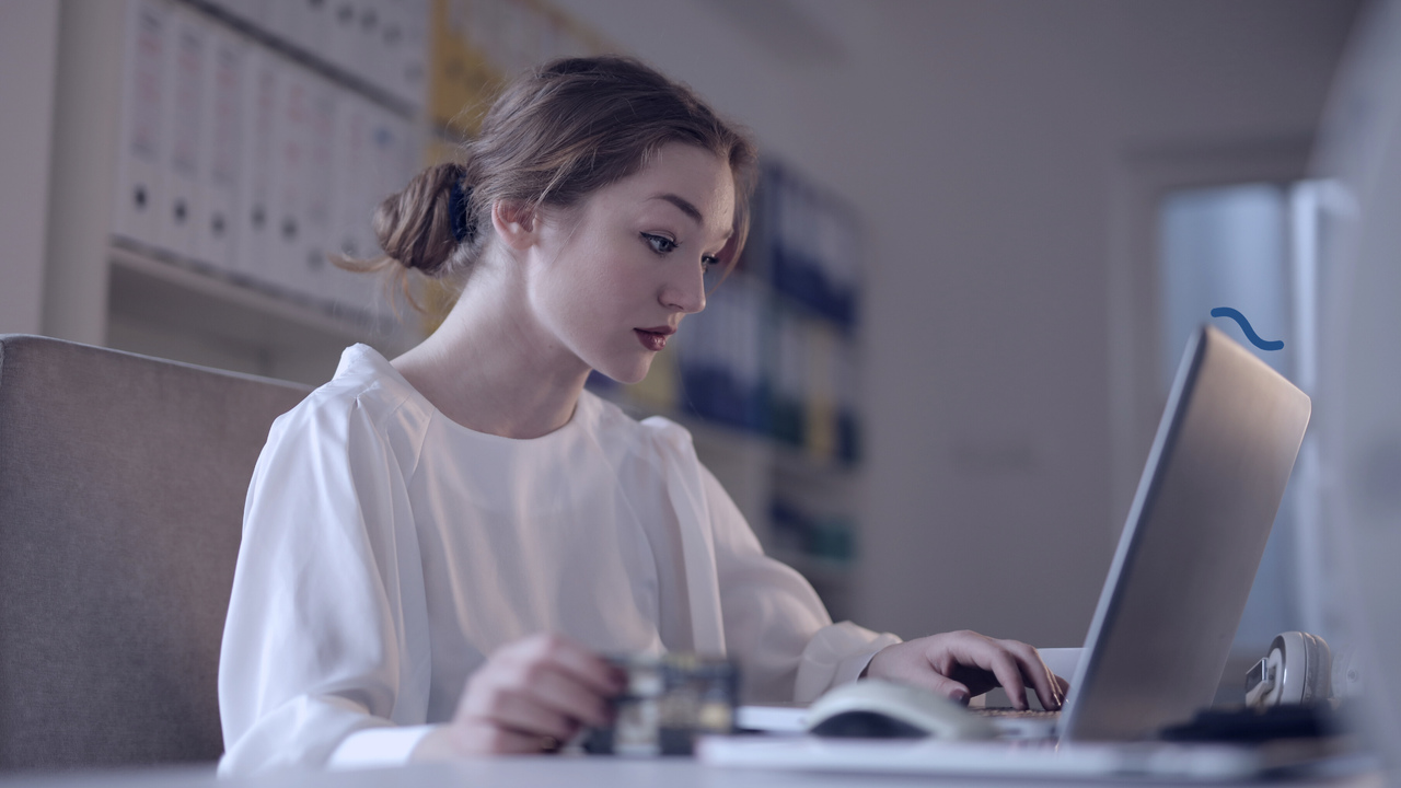 Mulher em frente ao computador. Imagem simboliza a profissional trabalhando com o controle de contas a pagar e receber.