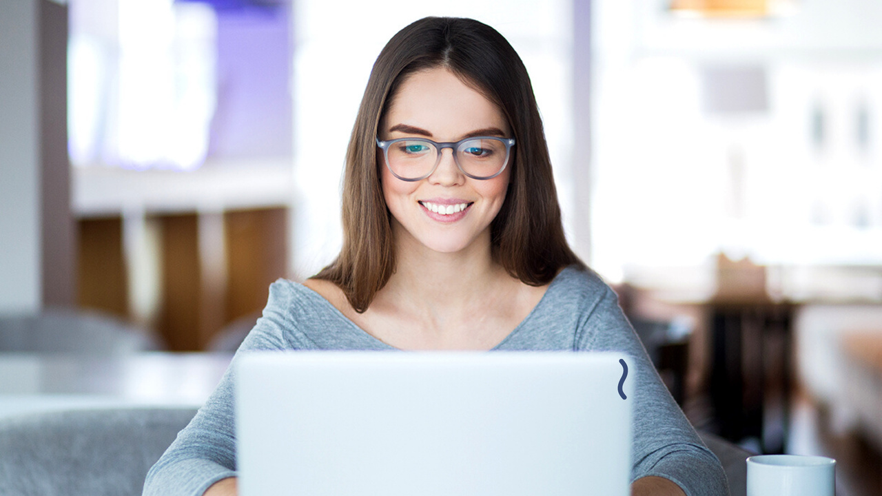 Menina em frente ao computador. Imagem simboliza profissional analisando indicadores industriais.