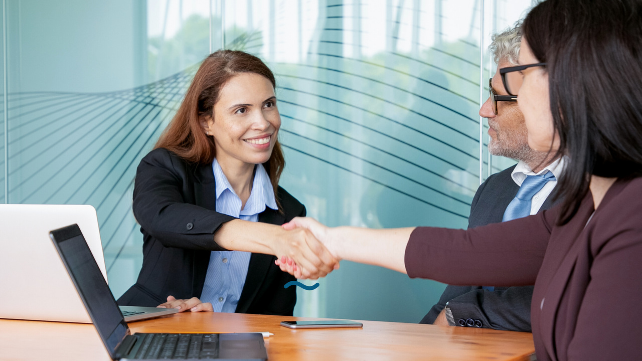 Aperto de mãos entre duas profissionais. Imagem simboliza que estão fechando o contrato de CRM de Vendas.
