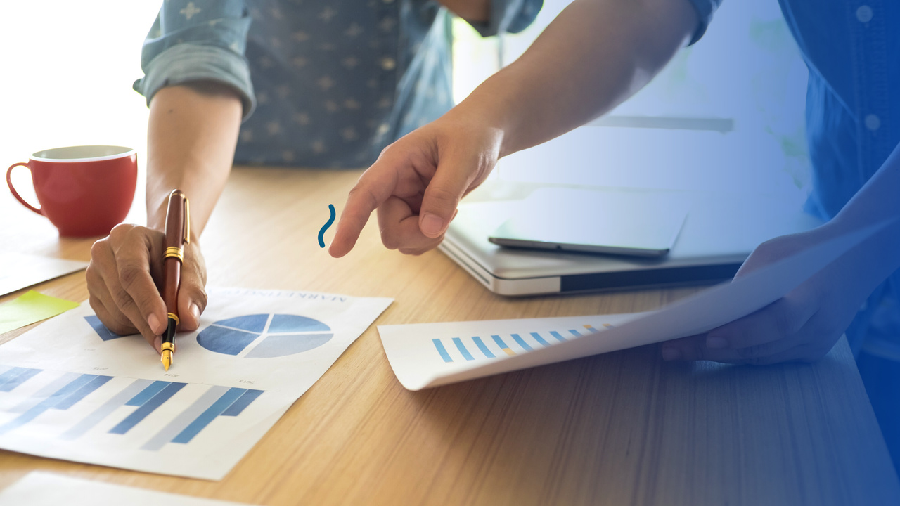 Dedos apontados para gráficos. Imagem simboliza o processo de definição do Fluxo de Cadência em Vendas.