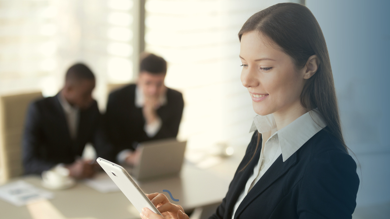 Profissional olhando para tablet. Imagem simboliza que está trabalhando com o planejamento avançado de produção (APS).